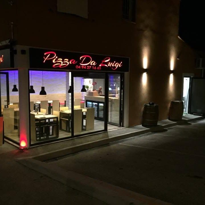 Détail de la façade de nuit, éclairage chaud et néon rouge