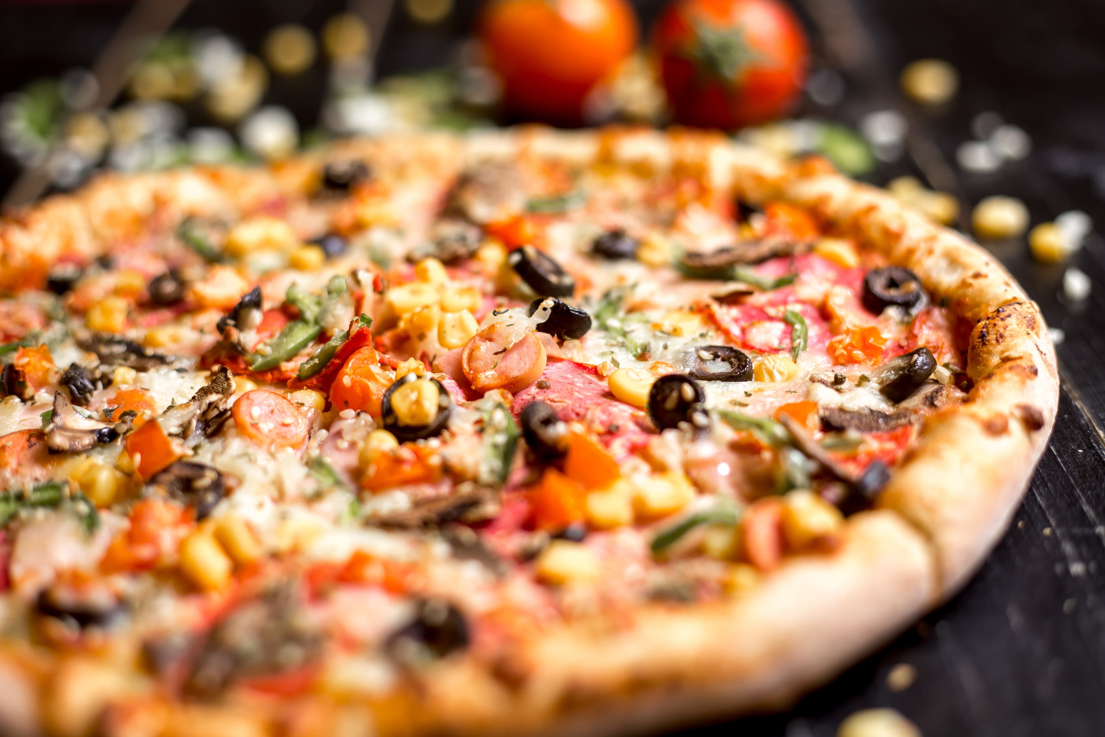 Pizza généreusement garnie, ingrédients frais visibles